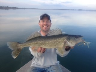 (One of many of the AWESOME walleye we jigged up from the waters of Fort Peck…notice the Glass Minnow in his mouth!!-courtesy of Trevor Johnson)